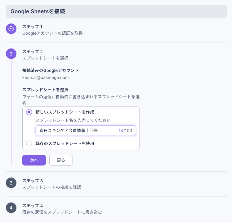 ステップ 2 スプレッドシートを選択：接続済みのGoogleアカウントは khan.ai@oakmega.com。スプレッドシートを選択で「新しいスプレッドシートを作成」を選び、スプレッドシート名に「森日スキンケア会員情報｜回答」（14/100）を入力。下に「既存のスプレッドシートを使用」の選択肢と、「次へ」「戻る」ボタン
